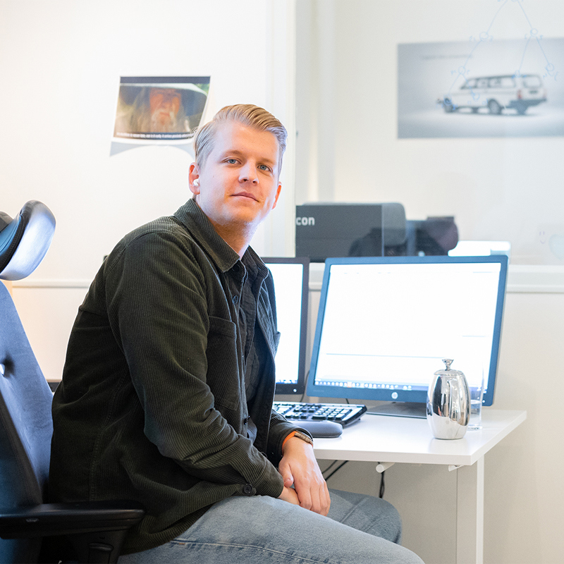 Utvecklare på Bilvisions kontor framför två skärmar